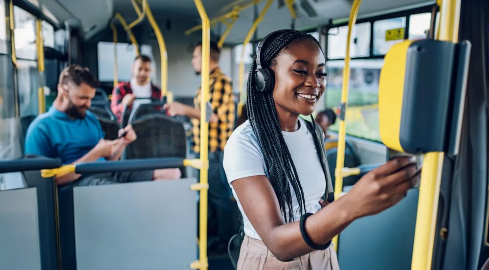 Sem Parar Empresas: mulher em ônibus aproximando o cartão à cobrança e demonstrando o vale-transporte: como funciona