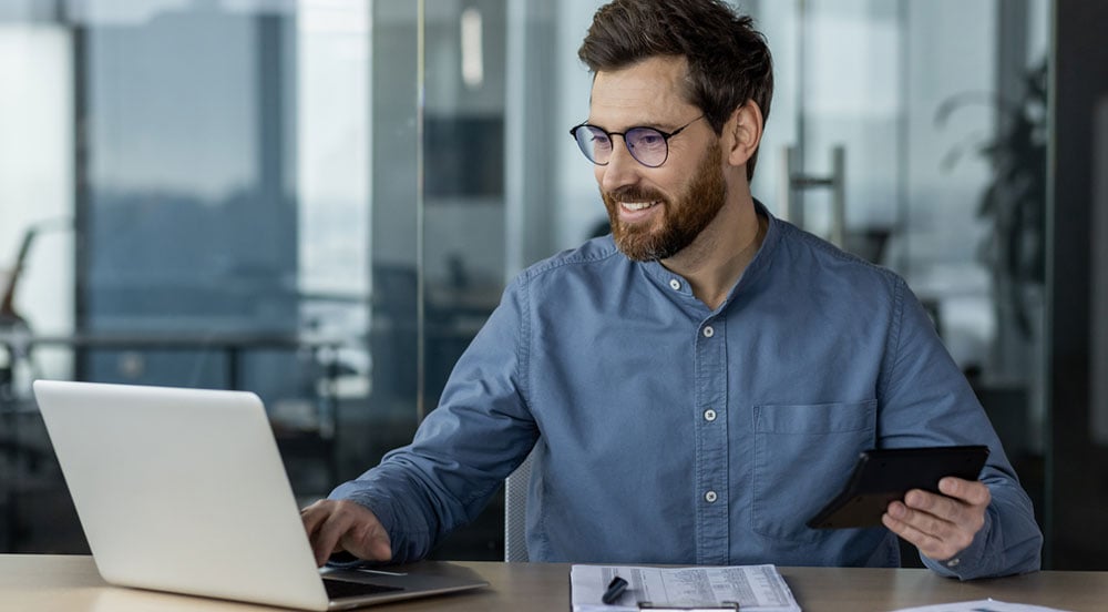 Homem do RH com notebook, planilhas e calculadora para realizar o cálculo do vale-transporte Sem Parar Empresas