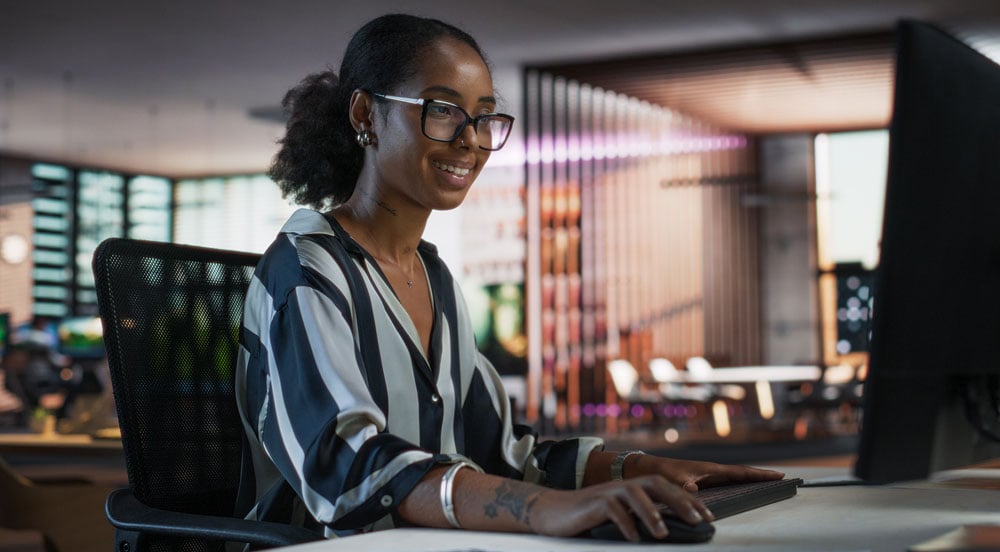 dicas_Sem Parar Empresas: mulher do departamento de RH sorrindo em frente ao computadorpara_departamento_de_rh_sem_parar_empresas