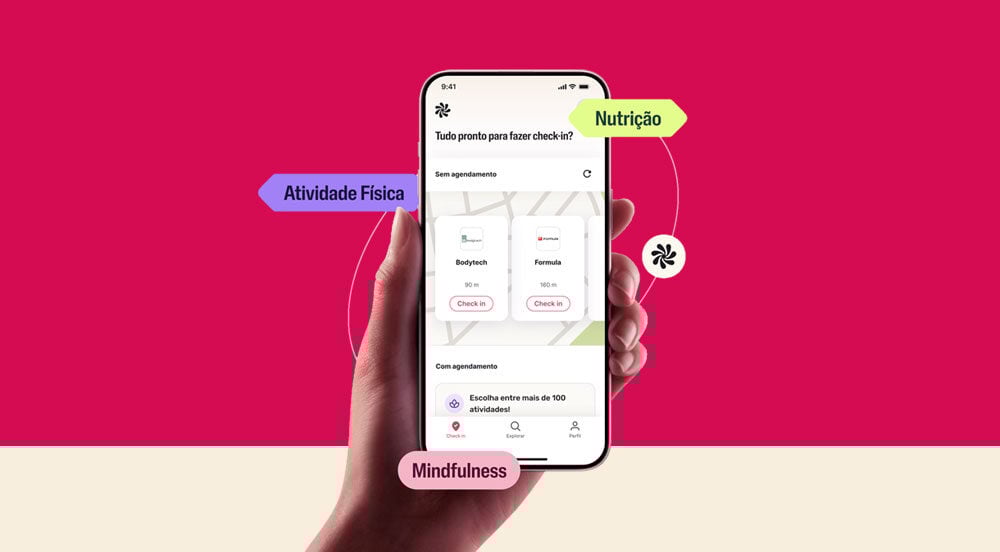 Mão segurando um celular com tela que mostra o que é Wellhub oferecido pela Sem Parar Empresas