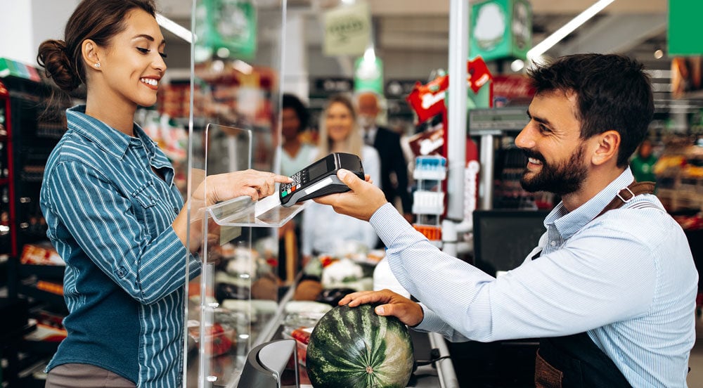 Sem Parar Empresas: mulher realizando pagamento em caixa de supermercado sabendo o vale-alimentação valor mínimo