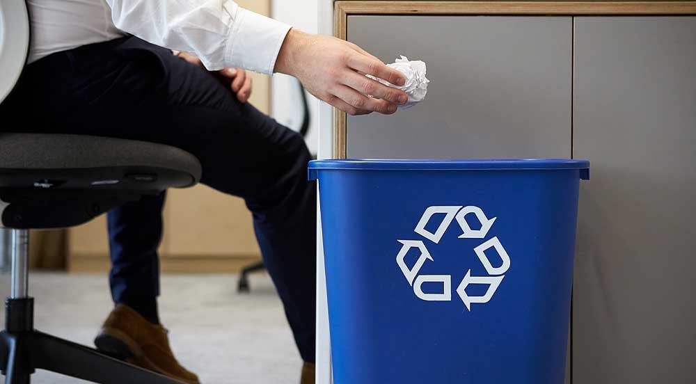 Sem Parar Empresas: homem sentado jogando papel no lixo reciclável para promover economia circular