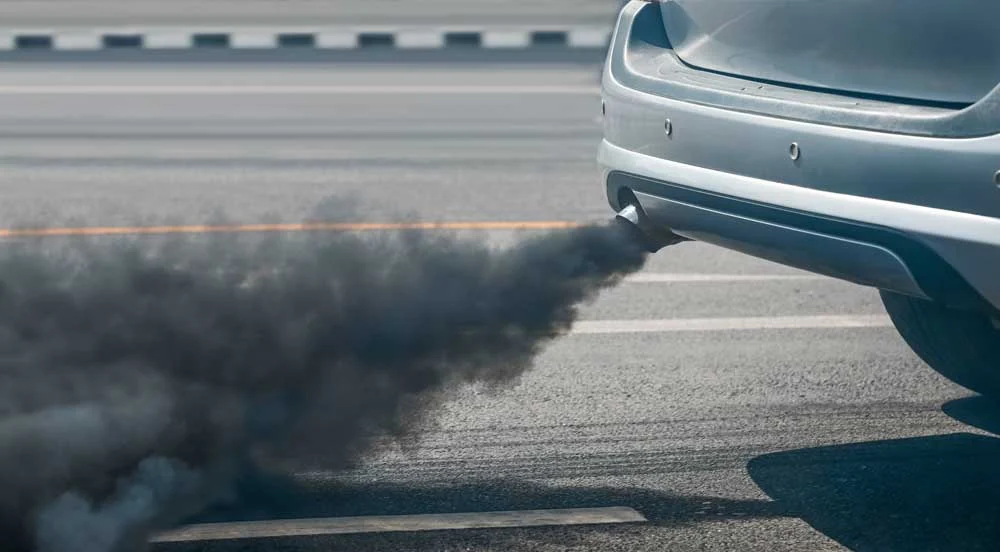 Sem Parar Empresas: escapamento de carro com fumaça escura colaborando para a poluição do ar