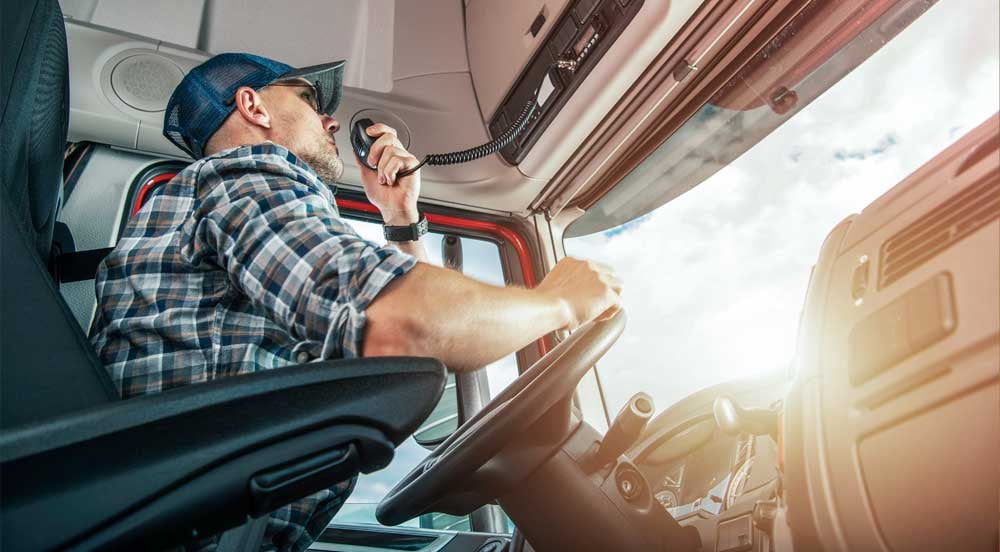 Sem Parar Empresas: caminhoneiro falando com a central em rádio, uma prática para alinhar informações e resuzir a síndrome de burnout na frota