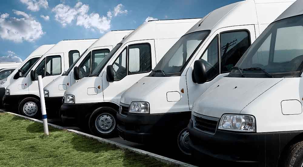 Sem Parar Empresas: várias vans brancas estacionadas em fila representando um dos inúmeros tipos de frota existentes