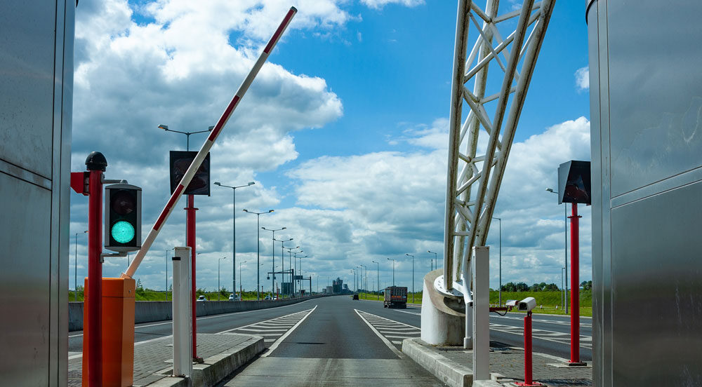 Cancela de cobrança de rodovia se abrindo com veículo que utiliza a tag de pedágio Sem Parar Empresas