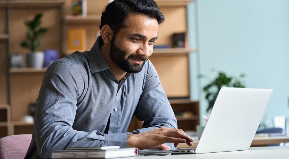 Sem Parar Empresas: homem utilizando notebook para gerenciar a frota no sistema de gerenciamento de transporte 