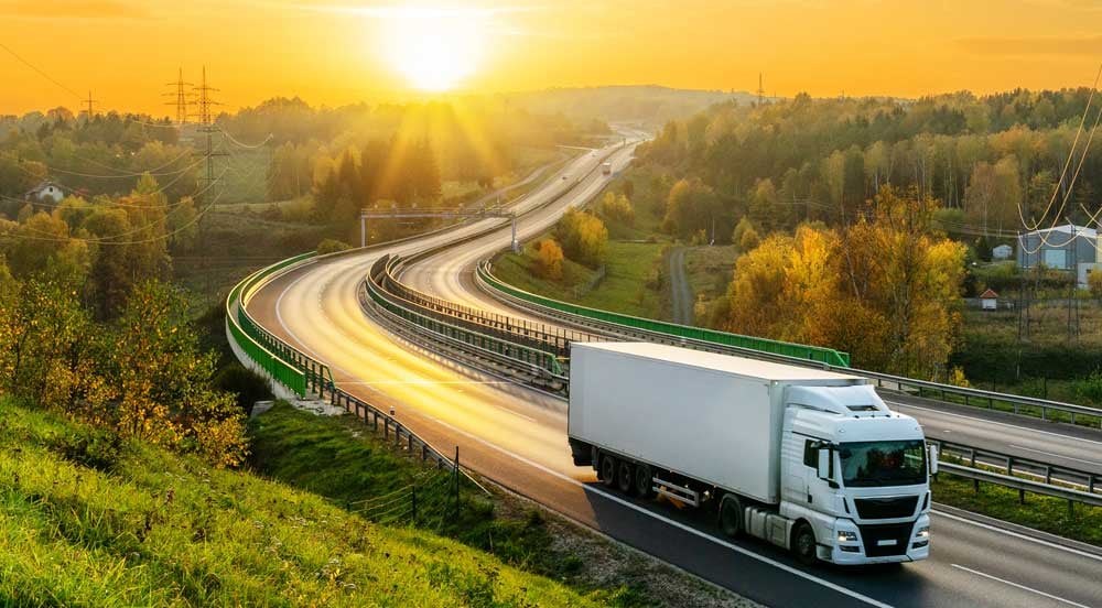 Sem Parar Empresas: caminhão em uma estrada com campos em volta representando a gestão sustentável de frotas 