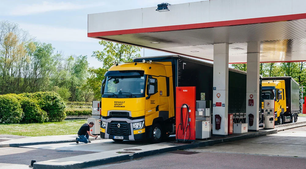 Dois caminhões grandes amarelos em posto de combustível para usar o CTF Abastecimento da Sem Parar Empresas