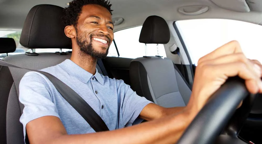 Homem sorrindo dentro do seu carro de trabalho para MEI