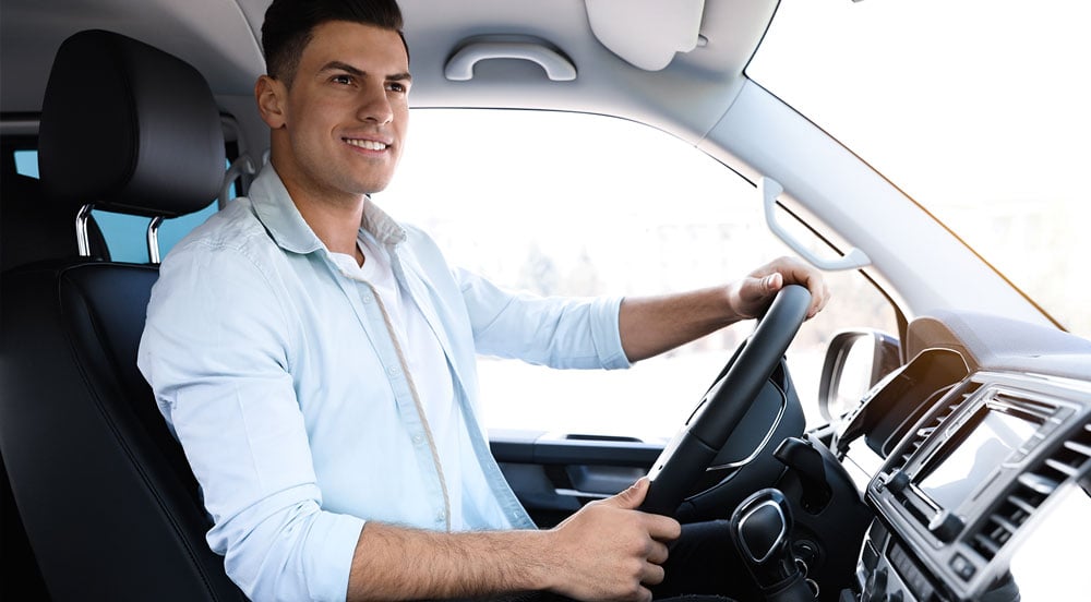 Sem Parar Empresas: Homem sorrindo dentro de veículo de frota, que não pode ser destinado ao uso particular do carro da empresa