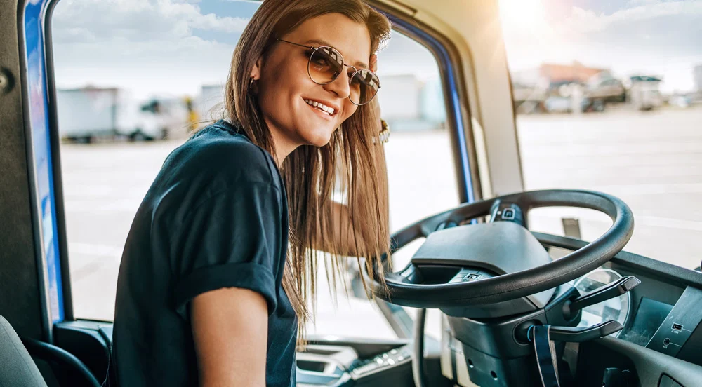 Mulher dentro de cabine de caminhão, usando a Gestão de Frete Sem Parar Empresas para caminhoneiro