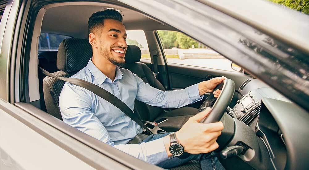 Sem Parar Empresas: motorista sorrindo enquanto dirige pois conhece as regras para uso de veículos da empresa