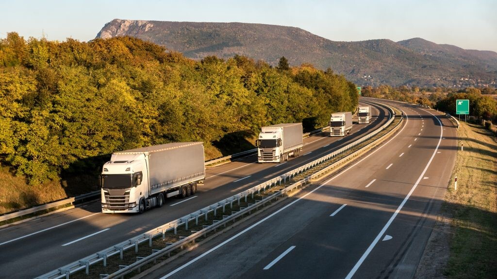 Frota de caminhões em movimento na estrada sendo controladas em tempo real e à distância pelo gestor