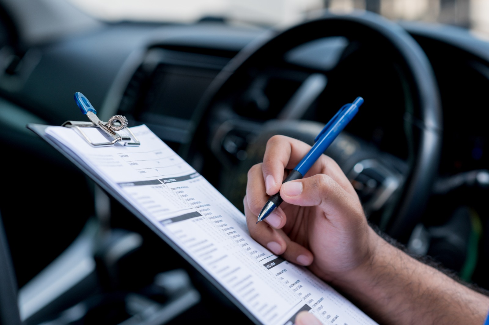 Gestor de frotas preenchendo uma planilha de checklist do veículo.