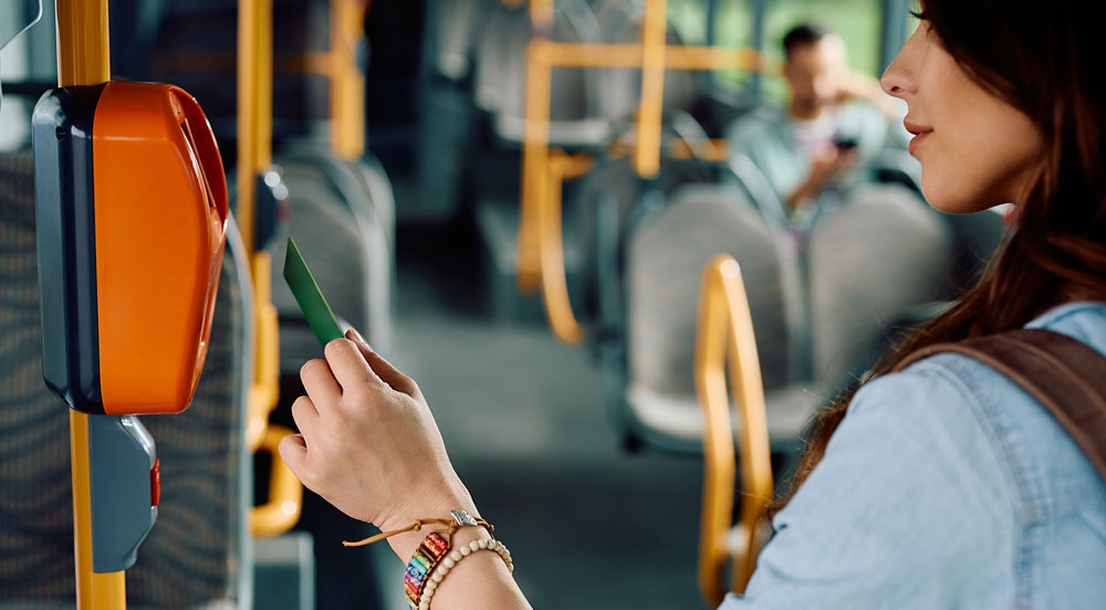 Mulher aproximando o cartão no leitor do ônibus para representar como funciona o vale-transporte Sem Parar Empresas