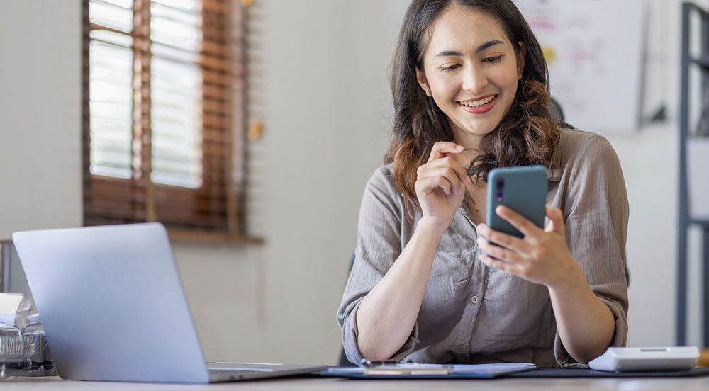 Sem Parar Empresas: mulher mexendo no celular para assinar seu aviso de férias