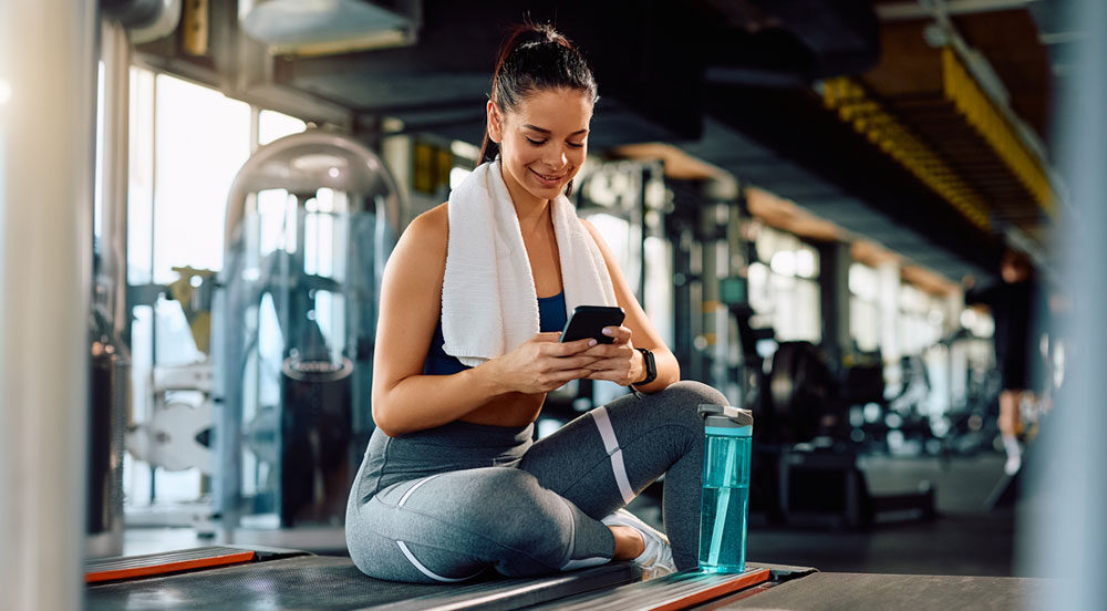 Mulher em academia usando Gympass planos para empresas disponibilizado pela Sem Parar Empresas