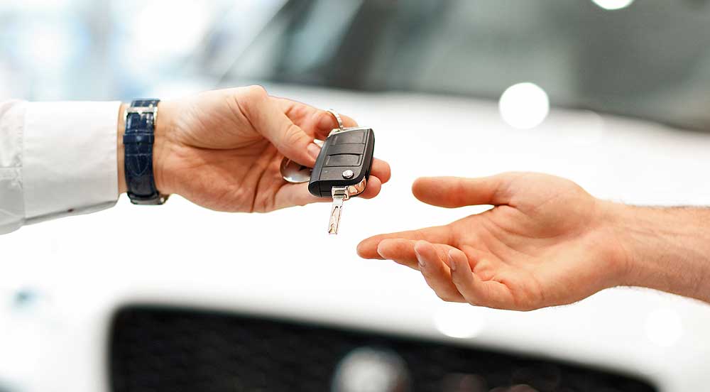 Sem Parar Empresas: mão entregando chave de carro por assinatura para outra mão