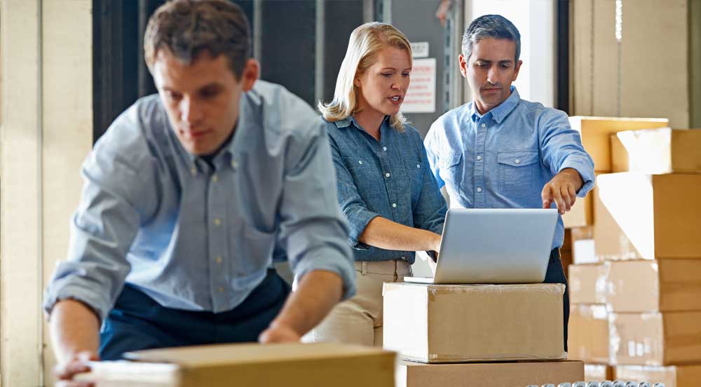 Sem Parar Empresas: três pessoas organizando caixas em um processo logístico