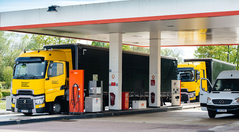 Dois caminhões e uma van em um posto de combustível onde irão abastecer com o sistema CTF da Sem Parar Empresas