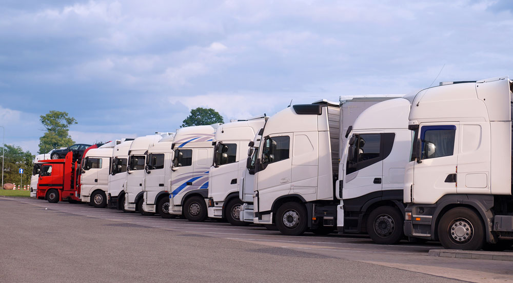 Sem Parar Empresas: frota de caminhões estacionada em fila no pátio da empresa