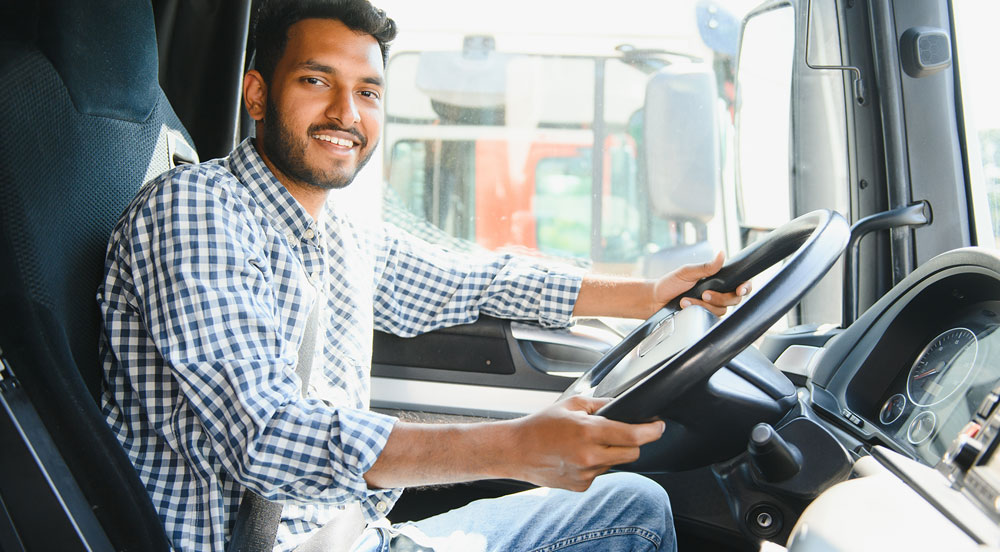 Sem Parar Empresas: homem que é MEI caminhoneiro dentro do veículo segurando a direção