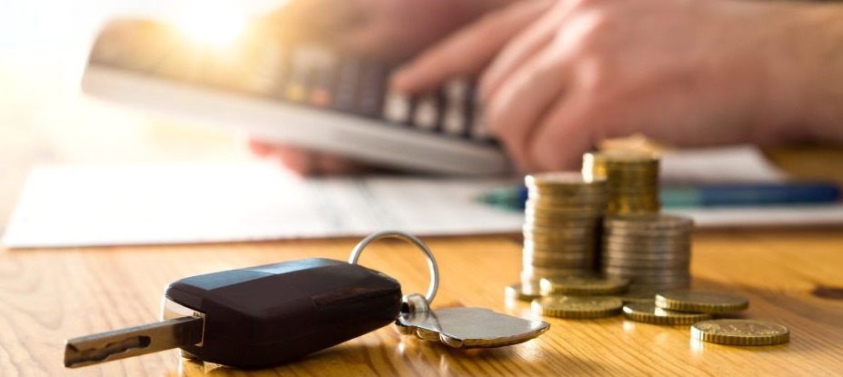 Sem Parar Empresas: uma mesa com uma chave de carro, alguma moedas e uma pessoa usando uma calculadora para verificar como calcular IPVA