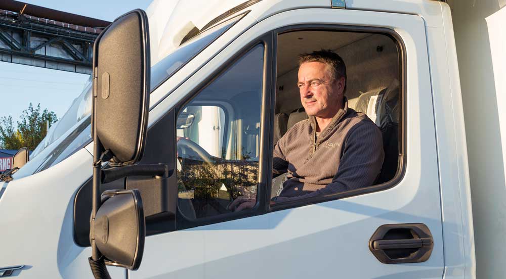 Sem Parar Empresas: homem que trabalha como TAC agregado dirigindo um caminhão branco