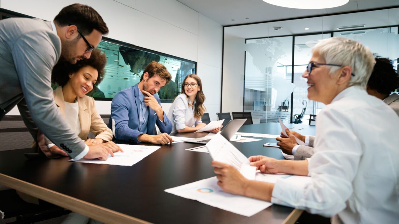 Time de colaboradores lendo comunicados sobre seus benefícios corporativos.
