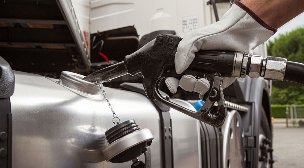 Mão de frentista inserindo a mangueira de combustível em um caminhão para representar como funciona o CTF Abastecimento Sem Parar Empresas