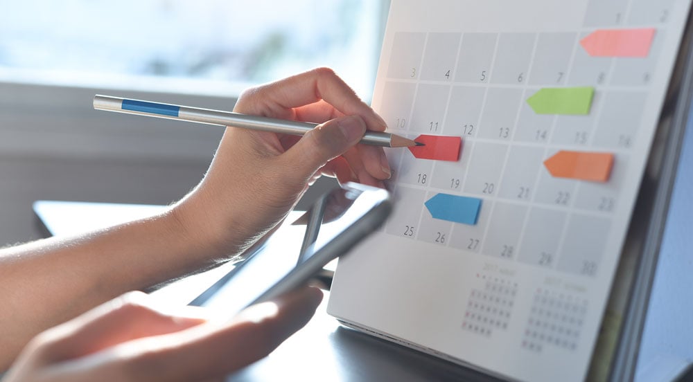 Sem Parar Empresas: mão anotando em calendário quando terá feriado prolongado