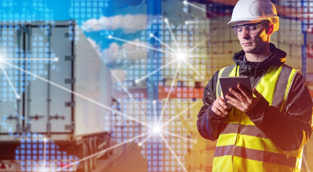 Sem Parar Empresas: homem com um tablet em mãos perto de um caminhão usando o software de fleet management