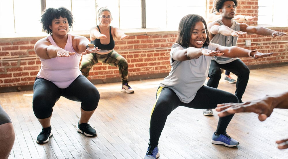 Pessoas em aula de ginástica que aceita um dos plano Gympass da Sem Parar Empresas