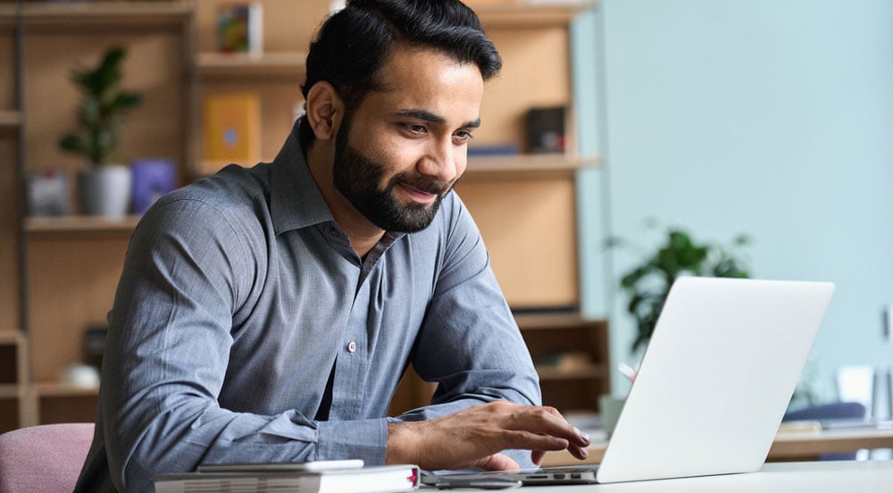 Homem em frente a um notebook fazendo a gestão eletrônica de frete com a Sem Parar Empresas.