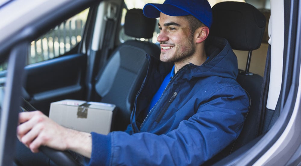 Motorista dentro do veículo que possui tag veicular Sem Parar Empresas para agilizar a entrega de produtos