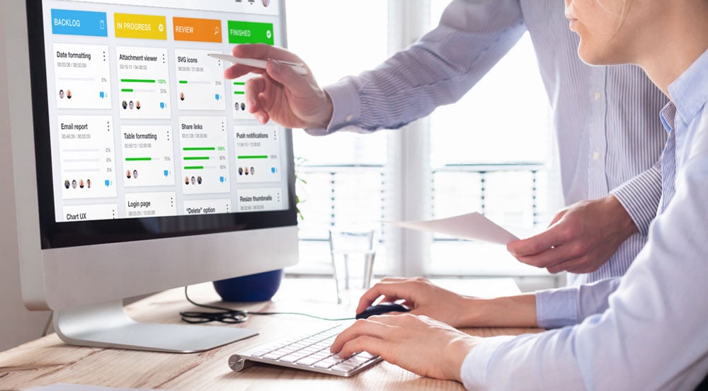 Sem Parar Empresas: duas pessoas analisando um monitor mostrando técnicas de metodologias ágeis para a empresa