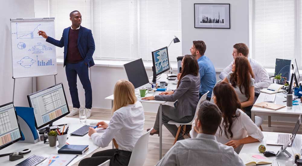 Sem Parar Empresas: homem palestrando em frente a um grupo que está em treinamento corporativo